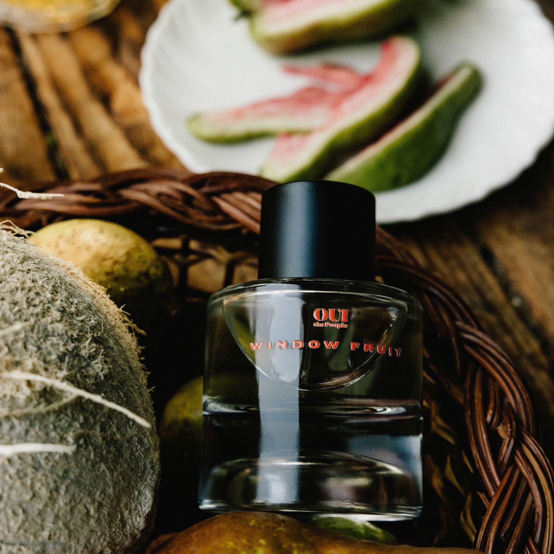 Perfume bottle with fruits on a wooden surface